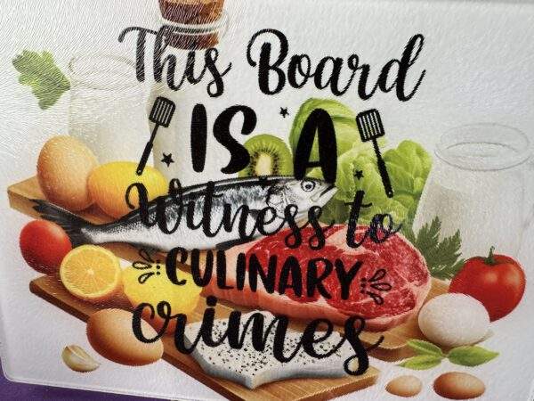A glass cutting board with an image of eggs, meat, fruit, and vegetables overlaid by the fun text, "This board is a witness to culinary crimes."