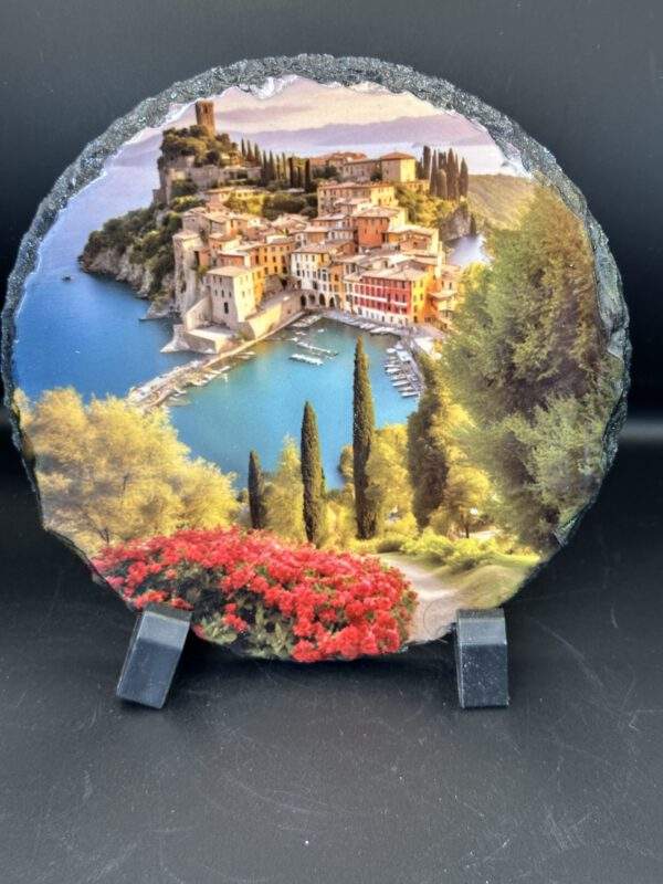 A circular cut of stone featuring a glossy image of a relaxed city by the sunny blue sea.