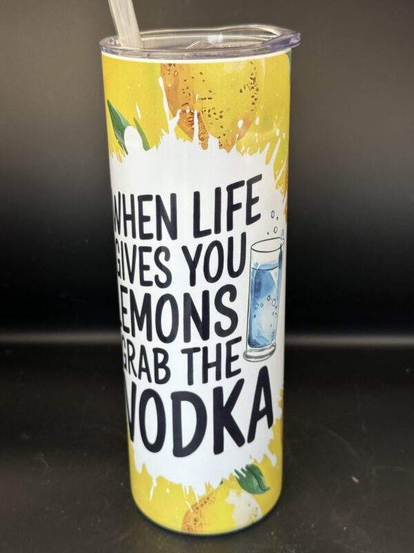 A tumbler with lid and straw, printed with bright yellow lemons and the text, 'When life gives you lemons, grab the vodka'