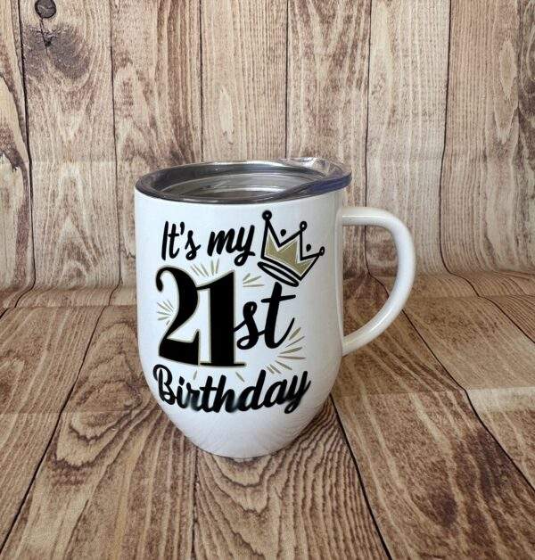 A white coffee mug with the image of a crown on the front and the text, 'It's my 21st birthday'
