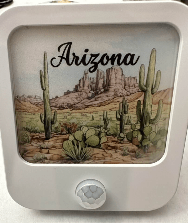 A square white nightlight with the image of the AZ desert and the words "Arizona" on it.