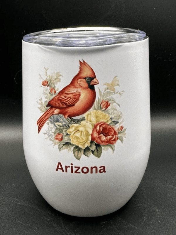 A white wine tumbler with lid picturing a bright red cardinal perched over some flowers. The word "Arizona" rests beneath.
