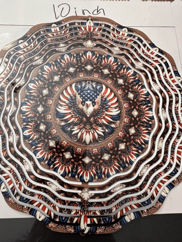 Red white and blue abstract pattern windspinner with eagle with red/white striped wings flying in the center.