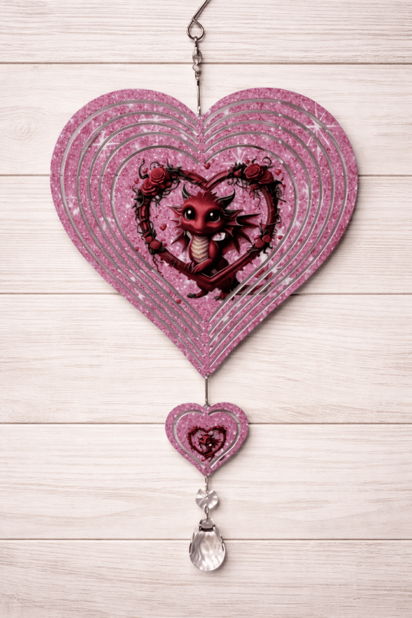 A little red dragon framed by a large red flowering heart of roses that it is holding. Windspinner is pink and cut into the shape of a heart.